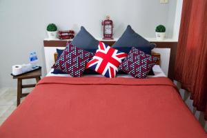 una cama con almohadas patrióticas encima en บ้านภูมิพันธ์ en Hat Yai