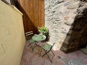 a small table and chairs sitting on a patio at Samour House - Centre ville in Saint-Vaast-la-Hougue