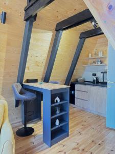 a kitchen with a blue island in a room with wooden ceilings at Forest Whisper - Mountain Retreat in Kovačka Dolina +12 photos