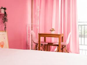 a pink room with a table and chairs at 오후여섯시펜션 in Jeju +51 photos