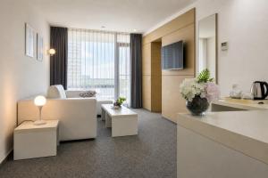 ein Wohnzimmer mit einem weißen Sofa und einem Tisch in der Unterkunft Hotel Melodia in Venus
