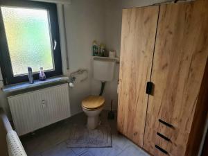 a bathroom with a toilet and a wooden door at Tippelsberg in Bochum +8 photos