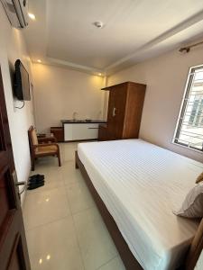 a bedroom with a large bed and a kitchen at LD Housing 9 in Ðống Thôn +7 photos