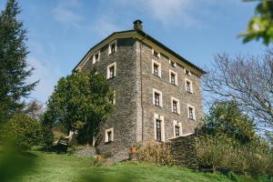 a large brick building on top of a grass field at Hotel Rural El Conceyu in Cabanella
