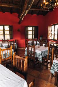 a restaurant with red walls and wooden tables and chairs at Hotel Rural El Conceyu in Cabanella +50 photos