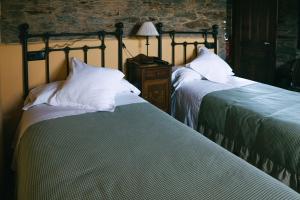 two beds sitting next to each other in a bedroom at Hotel Rural El Conceyu in Cabanella