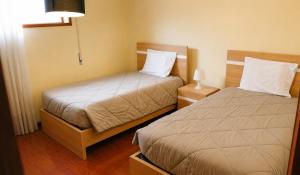 a bedroom with two beds and a lamp at Pôr do Sol in Vila Nova de Gaia