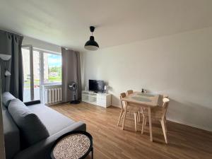 a living room with a couch and a table with chairs at Green & Quiet Apartment in Haapsalu in Haapsalu