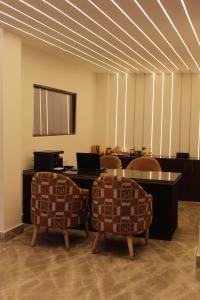 a room with two chairs and a table with a laptop at Hotel Yadu Vilas in Phata