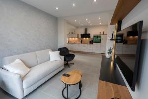 a living room with a white couch and a table at Ferienwohnnung EifelPanorama Berk in Dahlem