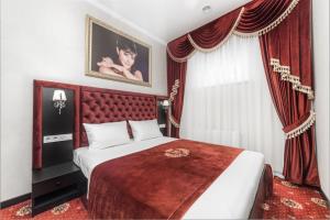 a bedroom with a bed with a red headboard and curtains at Arcadia Sea Breeze in Odesa