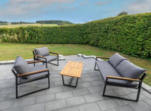 three chairs and a table on a patio at Ferienwohnnung EifelPanorama Berk in Dahlem