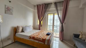 a small bedroom with a bed and a window at VFeel at Home- 2 BR Unit in Baguio