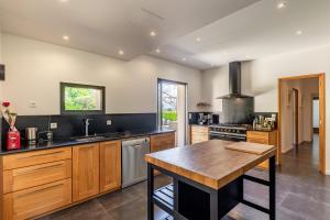 a large kitchen with wooden cabinets and a wooden table at La Cascade des Souvenirs Vacation rental just a short walk from Vaison in Vaison-la-Romaine