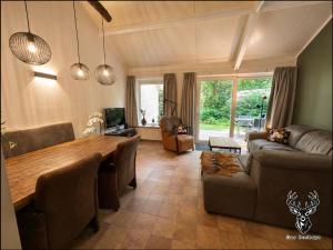 a living room with a wooden table and a couch at Ons Boshuys C18 in Garderen