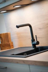 a kitchen sink with a black faucet on a counter at Ferienwohnnung EifelPanorama Berk in Dahlem +5 photos