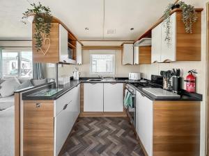 a kitchen with white cabinets and a stove top oven at Abi St David - Ukc9615 in Rowen +3 photos