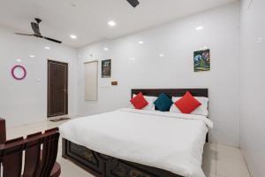 a bedroom with a bed with red and blue pillows at Sapthami Luxury Rooms in Guntūr +25 photos