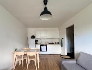 a living room with a table and chairs and a kitchen at Green & Quiet Apartment in Haapsalu in Haapsalu