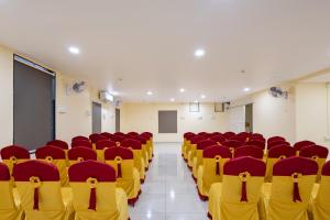 an empty lecture hall with red and yellow chairs at Sapthami Luxury Rooms in Guntūr