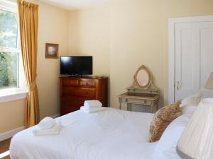 a bedroom with two beds and a tv on a dresser at Heather Cottage - Uk52177 in Leven