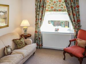a living room with a couch and a chair and a window at Heather Cottage - Uk52177 in Leven