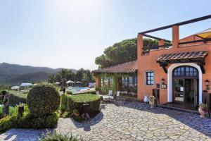 a building with a stone walkway in front of it at Essence Isola d'Elba - Le Picchiaie Resort in Portoferraio