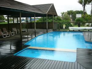 a large blue swimming pool with a wooden deck at Mid Coast Motor Inn in Macksville