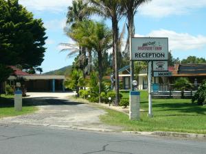 a sign on the side of a road in front of a building at Mid Coast Motor Inn in Macksville