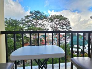 a white table on a balcony with a view of a city at VFeel at Home- 2 BR Unit in Baguio