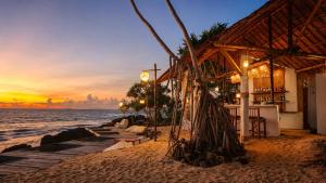 a restaurant on the beach with a sunset in the background at Moonlight Bay Resort in Ko Lanta