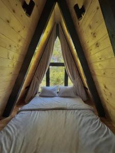 a bed in a tent with a window at Forest Whisper - Mountain Retreat in Kovačka Dolina