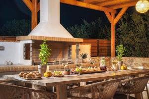 a wooden table with food on it in front of a fireplace at Alestone Villa by the sea in Vasilikos