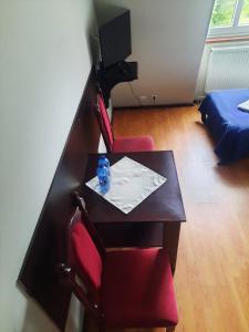 a room with a table and two red chairs at Dworek kwatery pracownicze in Kętrzyn