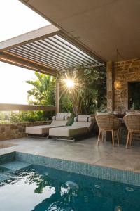 a swimming pool with chairs and a patio with a swimming pool at Gialova Hills - Luxury Villa with Private Pool, Sauna, Garden & Seaview in Gialova