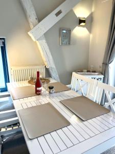 a table with two chairs and a bottle of wine on it at Ferienwohnung Kalleby 26 in Quern