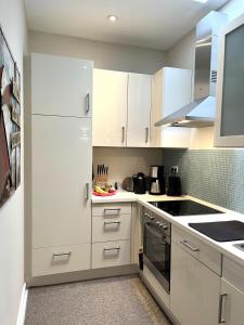 a white kitchen with white cabinets and appliances at Ferienwohnung Kalleby 26 in Quern