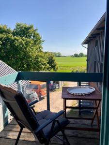 a chair sitting on a porch with a table at Ferienwohnung Kalleby 26 in Quern +11 photos