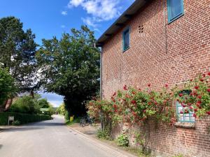 a brick building with flowers on the side of it at Ferienwohnung Kalleby 26 in Quern