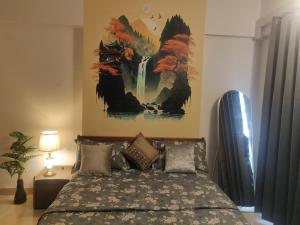 a bedroom with a bed with a painting on the wall at 2BHK Luxurious Apt near BKC in Mumbai