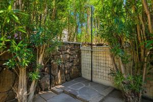 a garden with a stone fence and trees at Villetta Vespucci in Agrustos