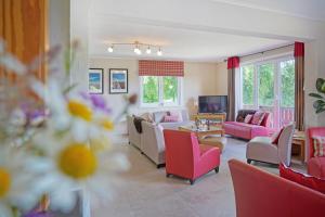 a living room with pink furniture and pink chairs at Le Milan Royal 26 pers, Malmedy, Balnéo, vue, calme in Malmedy