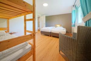 a room with two bunk beds and a chair at Le Milan Royal 26 pers, Malmedy, Balnéo, vue, calme in Malmedy