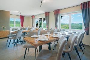 a dining room with tables and chairs and windows at Le Milan Royal 26 pers, Malmedy, Balnéo, vue, calme in Malmedy