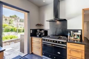a kitchen with a stove top oven next to a patio at La Cascade des Souvenirs Vacation rental just a short walk from Vaison in Vaison-la-Romaine