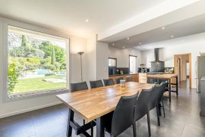a kitchen and dining room with a wooden table and chairs at La Cascade des Souvenirs Vacation rental just a short walk from Vaison in Vaison-la-Romaine