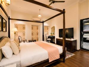 a bedroom with a bed and a television and a desk at Chandralok - A Boutique Hotel in Udaipur Near Fateh Sagar Lake in Udaipur +29 photos