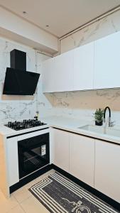 a white kitchen with a stove and a sink at chez moi sfax ville in Sfax