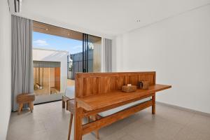 a room with a wooden table and a chair at Casa Cemagi by Orivista-LUX 3BR Tropical, 2 Min to Beach in Cemagi