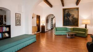a living room with two green couches and a painting at Essence Isola d'Elba - Le Picchiaie Resort in Portoferraio